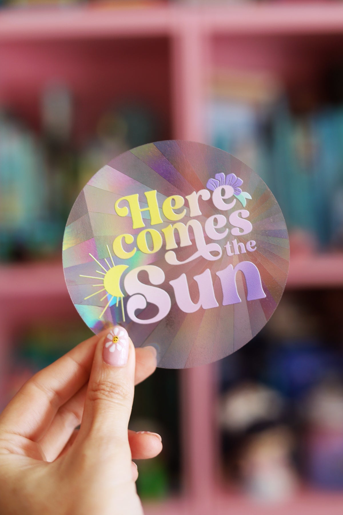 Autocollant vitrail "Here comes the sun" de la bonne sorcière, créateur d'arc-en-ciel, avec un design lumineux et coloré.