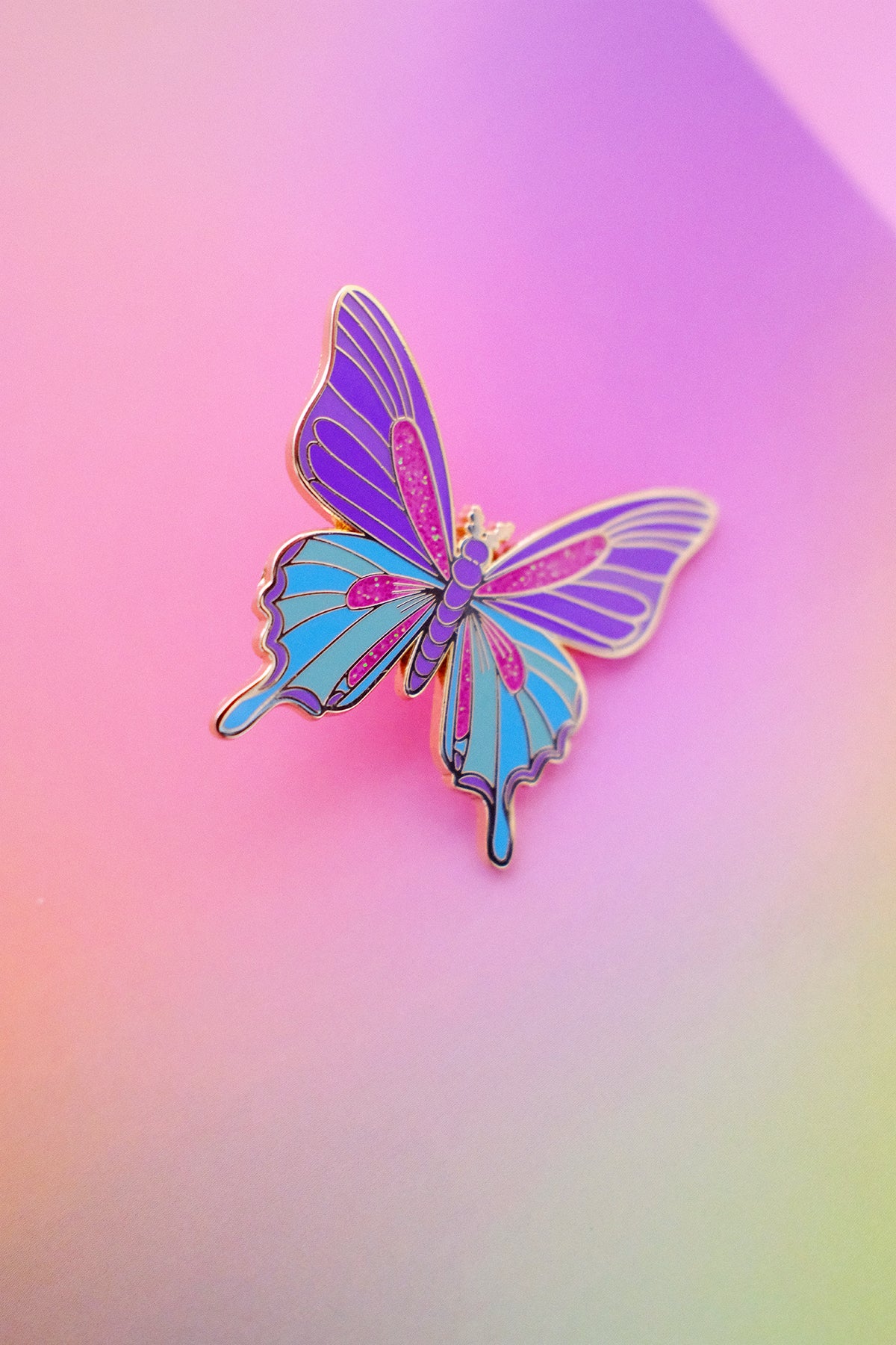 Pin's Papillon de la marque Shop Magique, détail coloré et orné, représentant un papillon délicat et élégant.