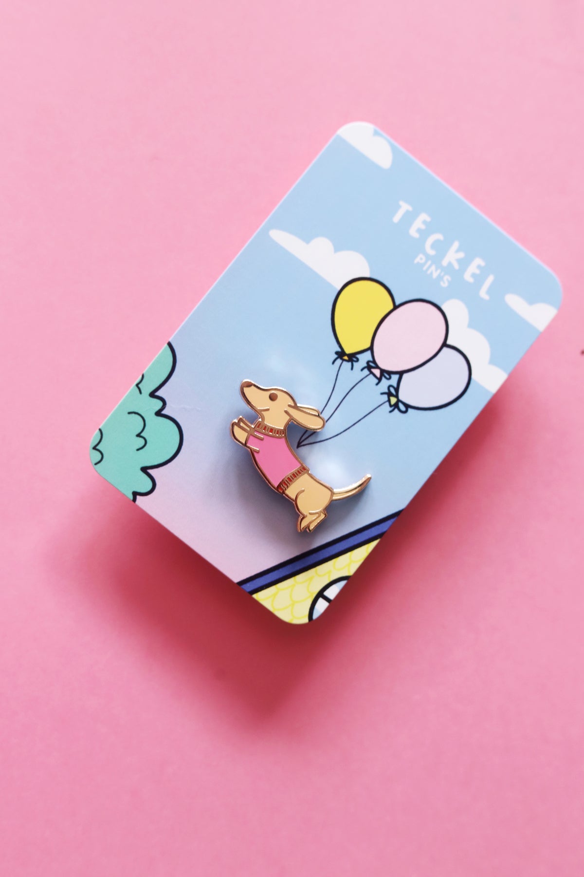 Pin's Teckel de la marque Shop Magique, illustration d’un chien teckel en métal coloré, posé sur fond neutre.