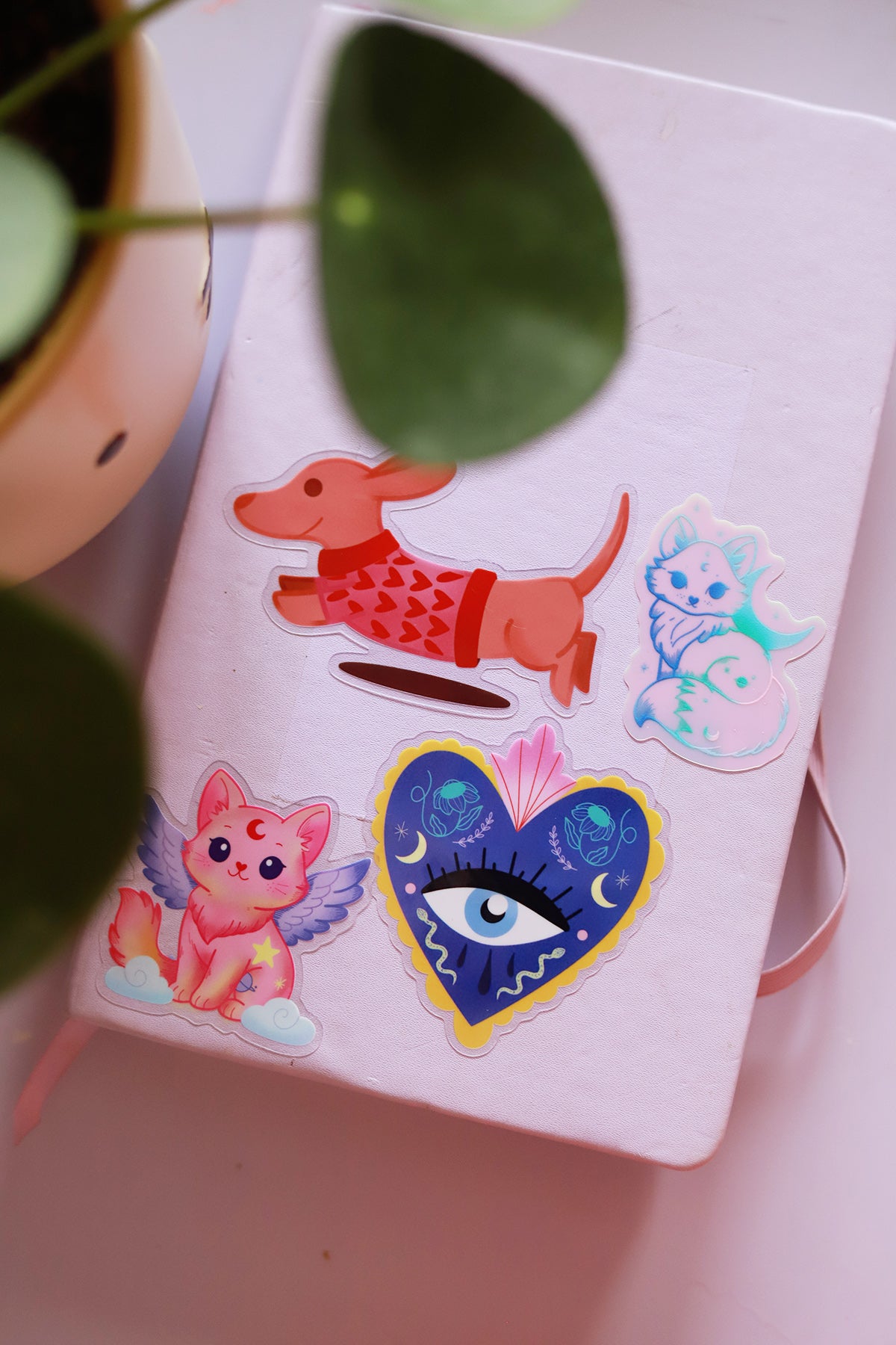 Porte-clés en sticker transparent avec chat ailé, illustré d’un design magique et coloré, idéal pour personnaliser vos accessoires.